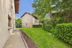 a brick walkway next to a building with a yard at Cozy Studio with a Garden in Gamsen