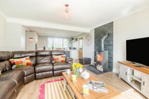 a living room with a leather couch and a fireplace at 3 Bed in Ebberston oc-s35053 in Ebberston