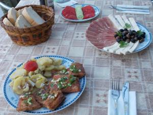 stół z talerzami jedzenia z tostami i owocami w obiekcie Guesthouse Feel Lake w mieście Virpazar