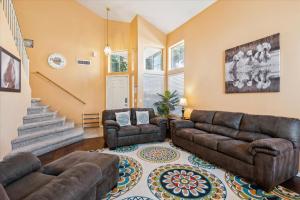 a living room with leather furniture and a staircase at Chandler Oasis in Chandler +18 photos