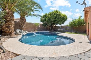 a pool in a backyard with palm trees at Chandler Oasis in Chandler