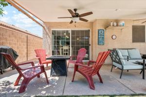 a patio with red chairs and a table with a fan at Chandler Oasis in Chandler