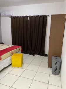 a bedroom with a bed and a window with curtains at mazzonetto ap 03 in Primavera do Leste +1 photo