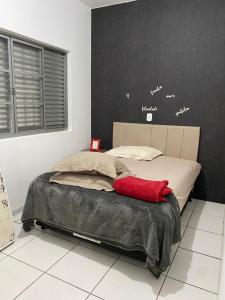 a bedroom with a bed with a red pillow on it at mazzonetto ap 03 in Primavera do Leste