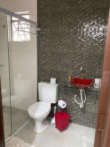 a bathroom with a toilet and a glass shower at mazzonetto ap 03 in Primavera do Leste