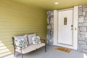 a porch with a bench and a white door at The KANtucky Derby Home in Derby