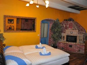 a bedroom with a bed and a brick fireplace at Centrum Tiffany Pension in Domažlice