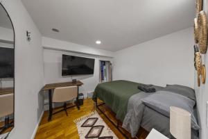 a bedroom with a bed and a desk and a tv at Double Room with shared bathroom in Times Square in New York