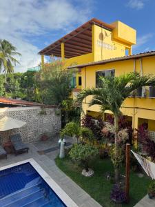 a villa with a swimming pool and a house at Flats Parada Obrigatoria in Maragogi