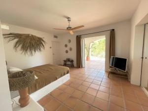 a bedroom with a bed and a flat screen tv at Finca LA SELVA, Exclusive Villa in Benimussa in San Antonio