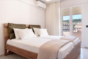 a bedroom with two beds and a large window at Riviera Zen apartment in Mesochórion