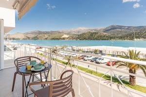 a balcony with a table and chairs and a view of a harbor at Riviera Zen apartment in Mesochórion