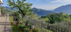 a fence with a tree and a view of the water at Il pozzo in Marone