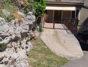 a house with a rock wall next to a driveway at Casa Bonaccorsi in Civitella Del Lago