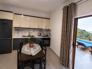 a kitchen and dining room with a table and a window at Amar Seaside in Ksamil