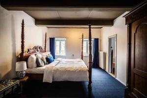 a bedroom with a large bed with blue curtains at Estrup Hovedgaard in Vejen