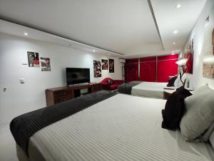 een hotelkamer met twee bedden en een flatscreen-tv bij Maya Sol Hotel in Cancun