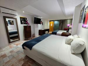 een hotelkamer met een groot bed en een spiegel bij Maya Sol Hotel in Cancun