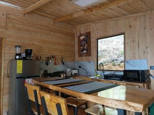 a kitchen with wooden walls and a table and a refrigerator at Calcopirita Stay House in Rivas +84 photos