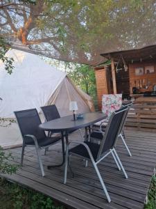 a table and chairs on a deck with a tent at Glamping Dübener Heide in Bad Schmiedeberg