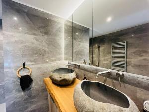 a bathroom with a stone sink and a mirror at Modern haven with garden in Marignier +8 photos