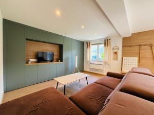 a living room with a couch and a table at Modern haven with garden in Marignier