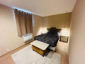 a small bedroom with a bed and a table at Modern haven with garden in Marignier