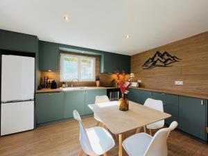 a kitchen with a table and chairs and a refrigerator at Modern haven with garden in Marignier