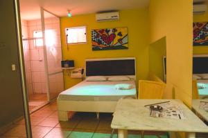 a small room with a bed and a table at La Passion Motel LTDA EPP in Jaú