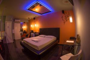 a bedroom with a bed and a blue light at La Passion Motel LTDA EPP in Jaú