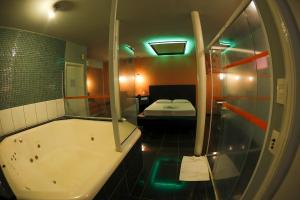 a bathroom with a tub and a bed in a room at La Passion Motel LTDA EPP in Jaú
