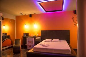 a bedroom with a bed and a purple light at La Passion Motel LTDA EPP in Jaú +12 photos