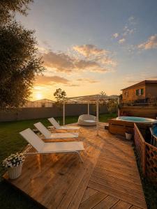 a deck with white lounge chairs and a pool at Villa Irabo in Albenga