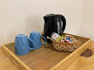 two blue mugs and a basket on a table at Hotel Carmelita in Aparecida +50 photos