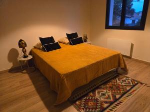 a bedroom with a bed with a yellow blanket and a rug at VILLA du VERNET avec JACUZZI in Vernet