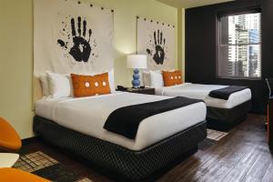 two beds in a hotel room with hands on the wall at ACME Hotel Chicago, Outset Collection by Hilton in Chicago