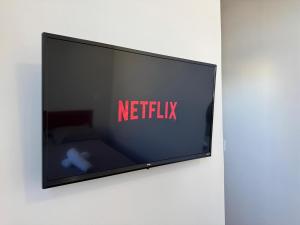 a flat screen tv with the netflix sign on it at Hotel Carmelita in Aparecida