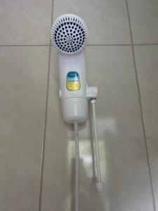 a hair dryer sitting on the floor in a bathroom at Suites Guarda do Embau in Palhoça