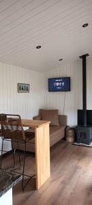 a room with a table and a couch and a stove at Tinys Abedul in Lago Meliquina