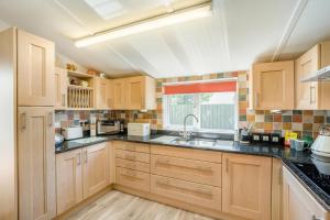 a kitchen with wooden cabinets and a sink and a window at 2 Bed in Middlezoy oc-s33601 in Middlezoy