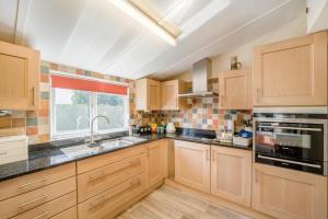 a large kitchen with wooden cabinets and a window at 2 Bed in Middlezoy oc-s33601 in Middlezoy +23 photos