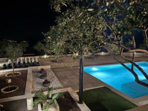 a backyard with a swimming pool at night at Villa Maginja in Sutivan