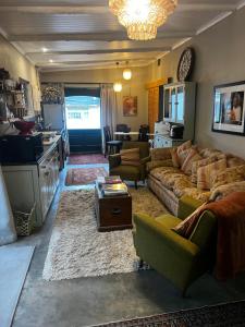 a living room with a couch and a table at Greyton Cottage in Greyton