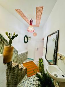 a bathroom with a sink and a mirror at Dar 07 in Oulad Akkou