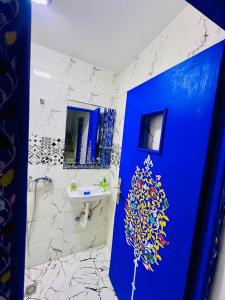a bathroom with a blue door and a sink at Dar 07 in Oulad Akkou