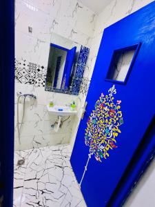 a bathroom with a blue door and a sink at Dar 07 in Oulad Akkou