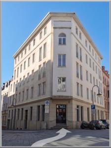a large white building on a city street at Fabcap Kapsel Apartment in Halle an der Saale