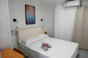 a bedroom with a white bed and a table and a picture at Nadi Easy Home Near McDonalds in Nadi