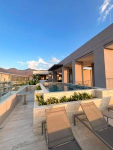 a balcony of a building with chairs and a pool at Bello Horizonte, Aeropuerto, playa Dormida in Santa Marta