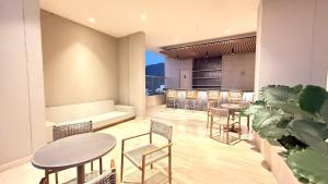 a room with tables and chairs and a couch at Bello Horizonte, Aeropuerto, playa Dormida in Santa Marta